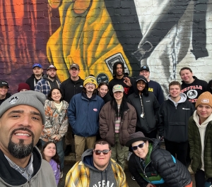 Group of students in front of art wall